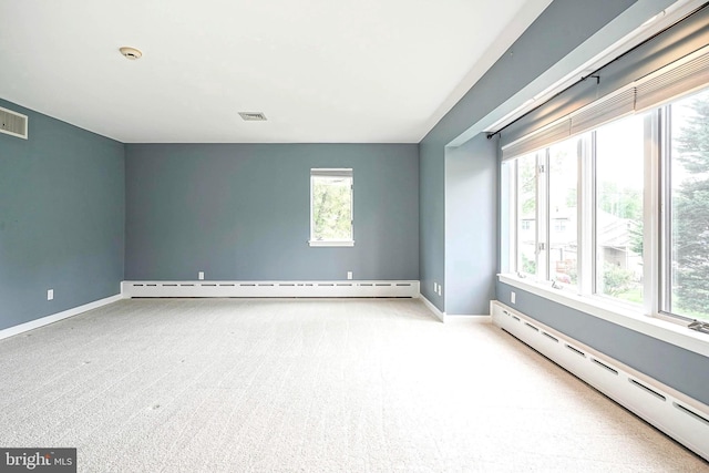unfurnished room featuring a baseboard radiator, healthy amount of natural light, and baseboards