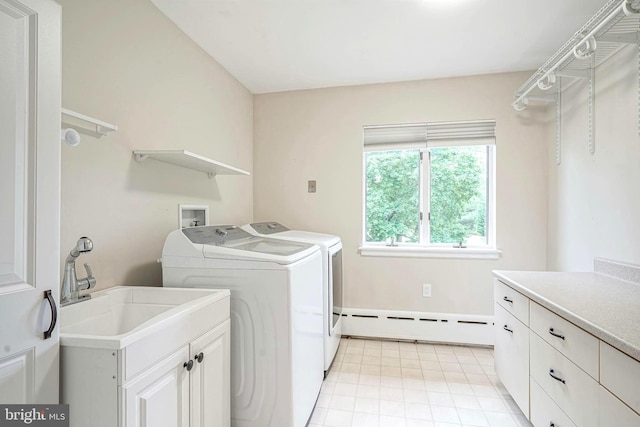 clothes washing area with baseboard heating, separate washer and dryer, cabinet space, and light tile patterned floors