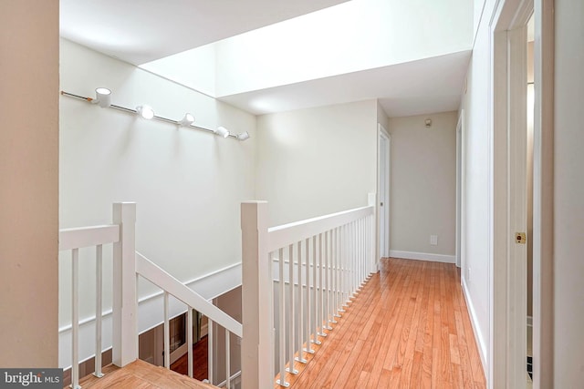 hallway with an upstairs landing and hardwood / wood-style floors