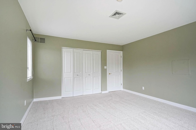 unfurnished bedroom with a closet, baseboards, and carpet