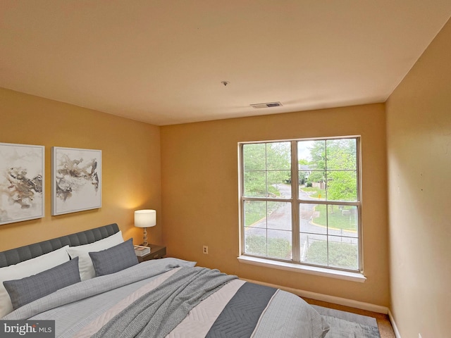 bedroom featuring baseboards, multiple windows, and visible vents