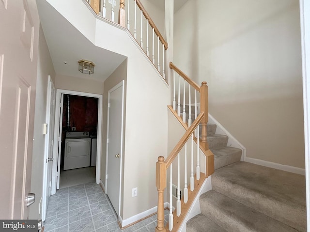 staircase with carpet floors, baseboards, and independent washer and dryer