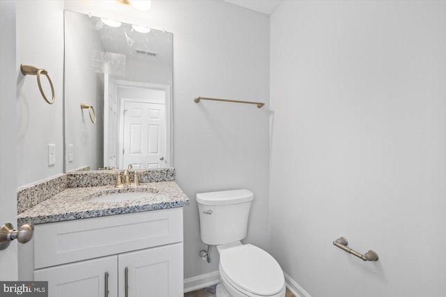 bathroom featuring toilet, visible vents, baseboards, and vanity