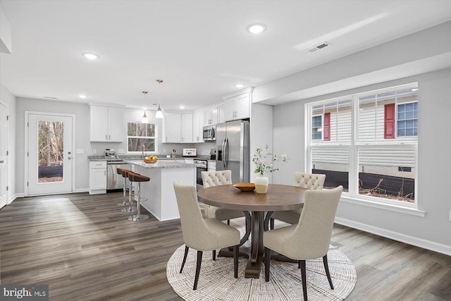 dining space with dark wood-style flooring, baseboards, visible vents, and recessed lighting