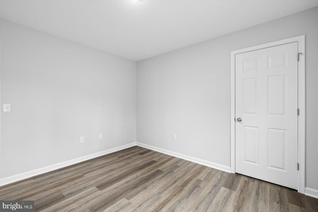 empty room with wood finished floors and baseboards