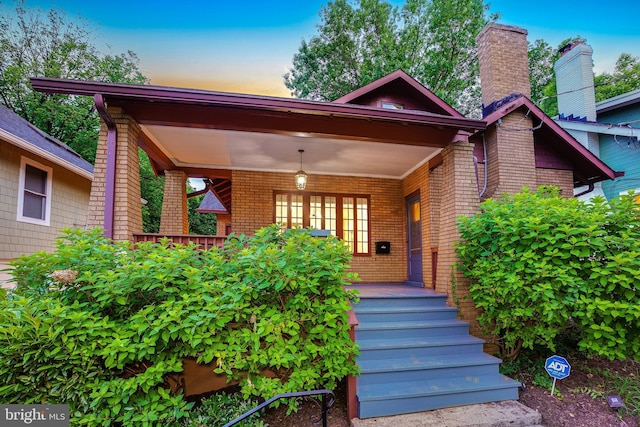 7507 Carroll Ave, Takoma Park, MD 20912 - exterior entry at dusk with a porch and brick siding