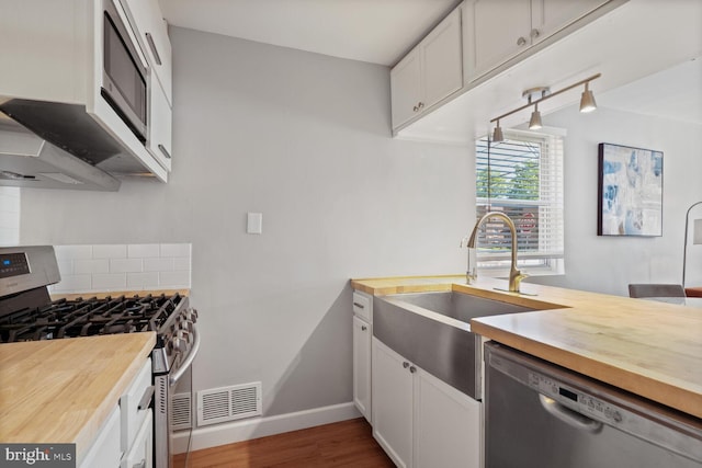 6526 N Capitol St NW, Washington, DC 20012 - kitchen featuring stainless steel appliances, butcher block counters, a sink, and dark wood-style floors