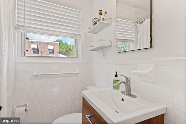 6526 N Capitol St NW, Washington, DC 20012 - bathroom with tile walls, vanity, toilet, wainscoting, and a shower with curtain