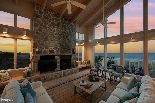 40113 Owens Ct, Fenwick Island, DE 19944 - living area featuring high vaulted ceiling, a fireplace, beamed ceiling, a ceiling fan, and wood ceiling