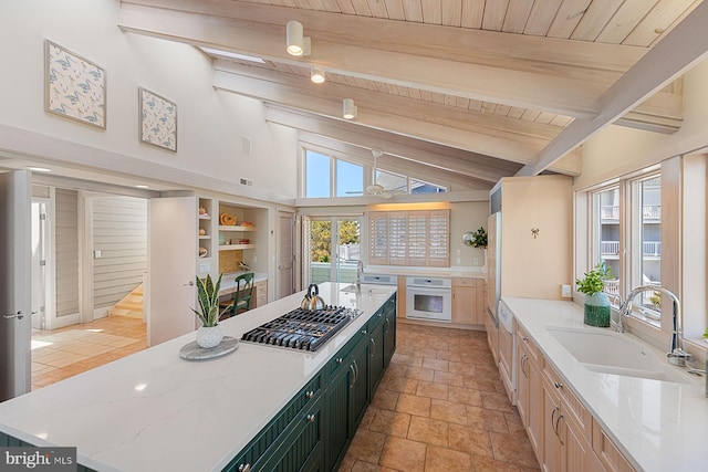40113 Owens Ct, Fenwick Island, DE 19944 - kitchen with a sink, a large island, stainless steel gas stovetop, a ceiling fan, and vaulted ceiling with beams