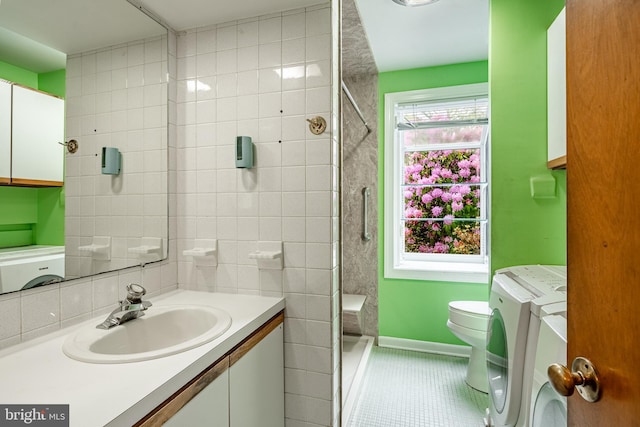 full bath with washer and dryer, toilet, tile patterned floors, vanity, and a shower