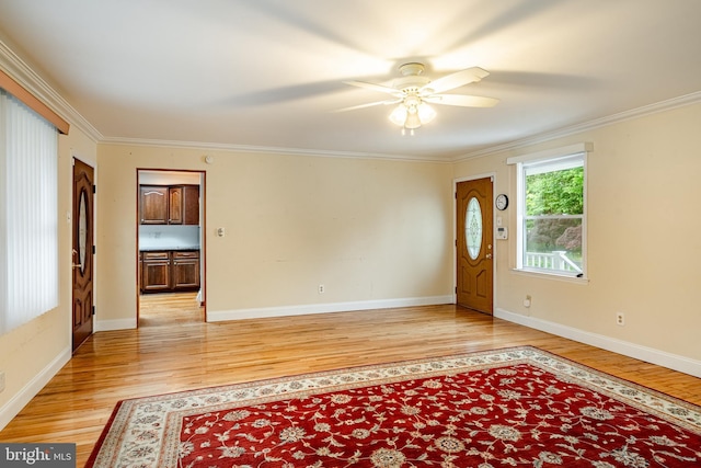 foyer with light wood-style flooring, a ceiling fan, crown molding, and baseboards