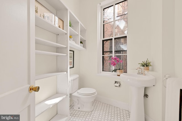 2133 Bolton St, Baltimore, MD 21217 - bathroom with toilet, baseboards, and a sink