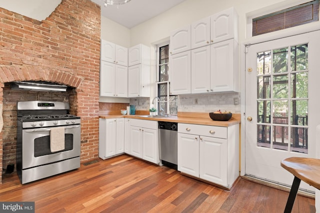 2133 Bolton St, Baltimore, MD 21217 - kitchen featuring stainless steel appliances, a sink, light wood-style flooring, and white cabinetry