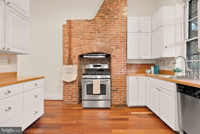 2133 Bolton St, Baltimore, MD 21217 - kitchen featuring appliances with stainless steel finishes, a sink, light wood-style floors, and backsplash