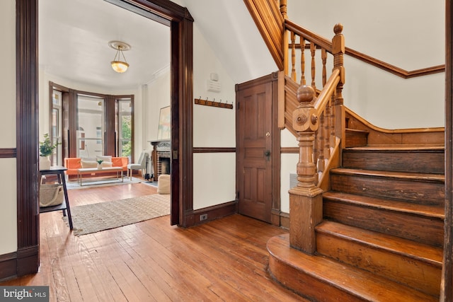 2133 Bolton St, Baltimore, MD 21217 - entryway with stairway, wood-type flooring, crown molding, and a fireplace