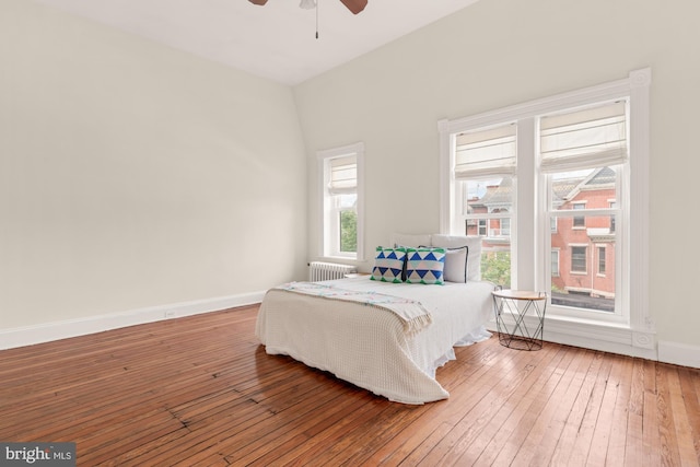 2133 Bolton St, Baltimore, MD 21217 - bedroom featuring hardwood / wood-style floors, baseboards, radiator, and ceiling fan