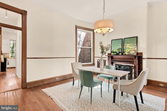 2133 Bolton St, Baltimore, MD 21217 - dining space with light wood-type flooring, a fireplace, baseboards, and ornamental molding