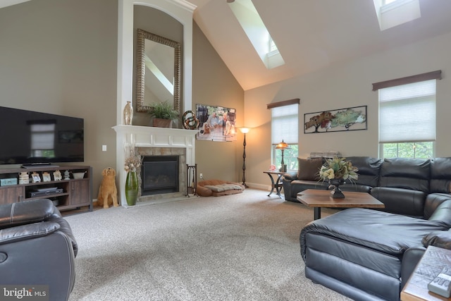 living area featuring a skylight, carpet flooring, a high end fireplace, and high vaulted ceiling