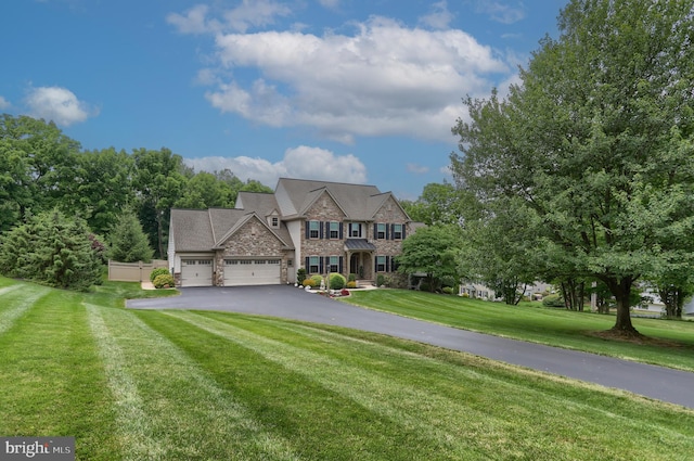 view of front of home with stone siding, driveway, a garage, and a front lawn