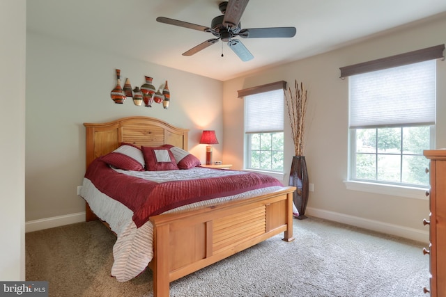 bedroom with light carpet, baseboards, and ceiling fan