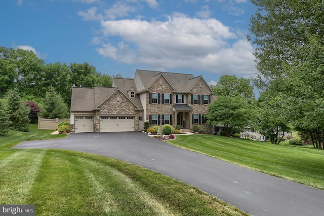 view of front of property featuring a garage, a front lawn, stone siding, and driveway