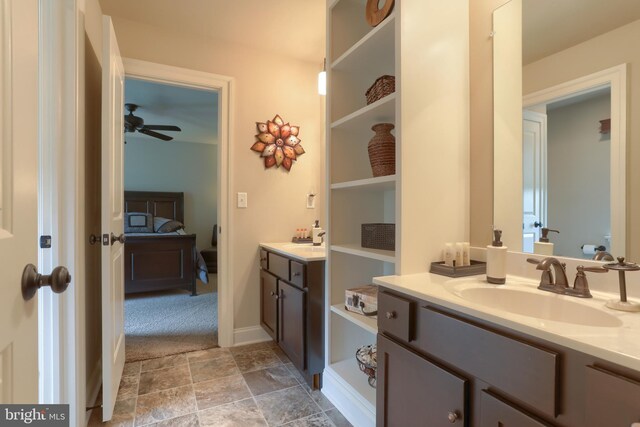 bathroom featuring connected bathroom, a ceiling fan, vanity, and stone finish floor