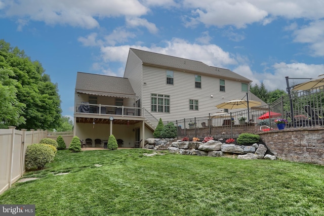back of property with a lawn, a patio area, stairway, a wooden deck, and a fenced backyard