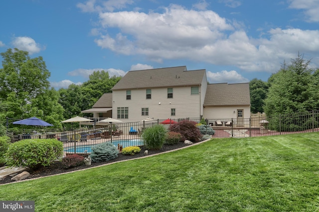 rear view of house featuring a yard, a patio, fence, and a fenced in pool
