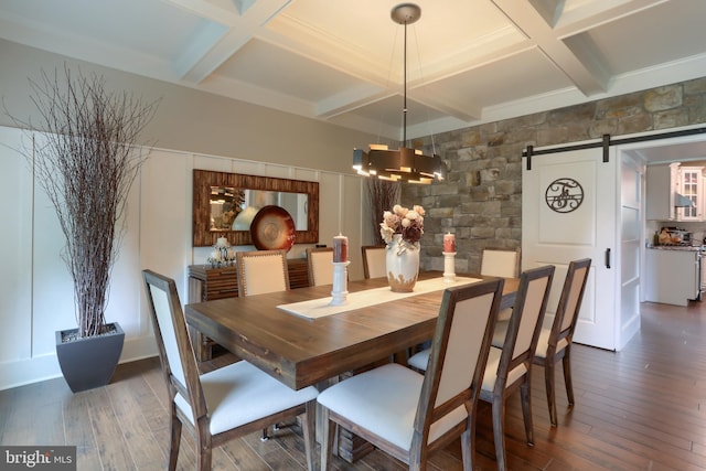 dining space featuring a chandelier, a barn door, coffered ceiling, and hardwood / wood-style flooring