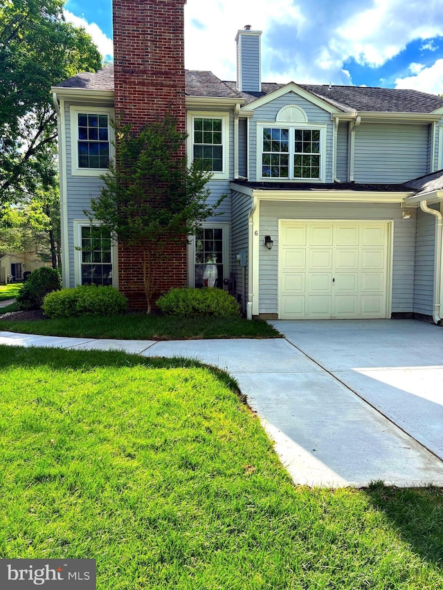 view of front of property featuring driveway, a chimney, and a front yard