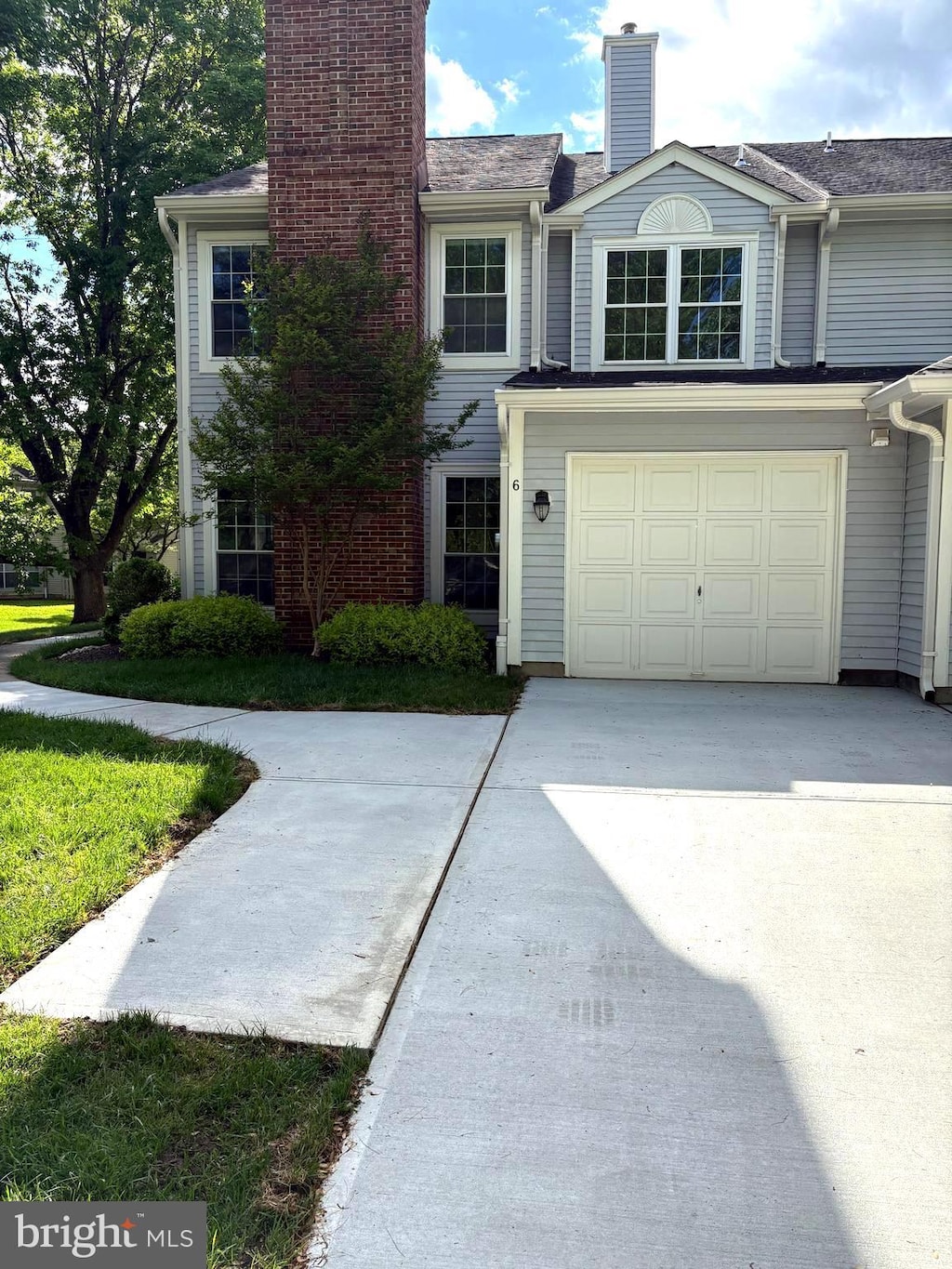 view of front of house featuring a chimney, a garage, and concrete driveway
