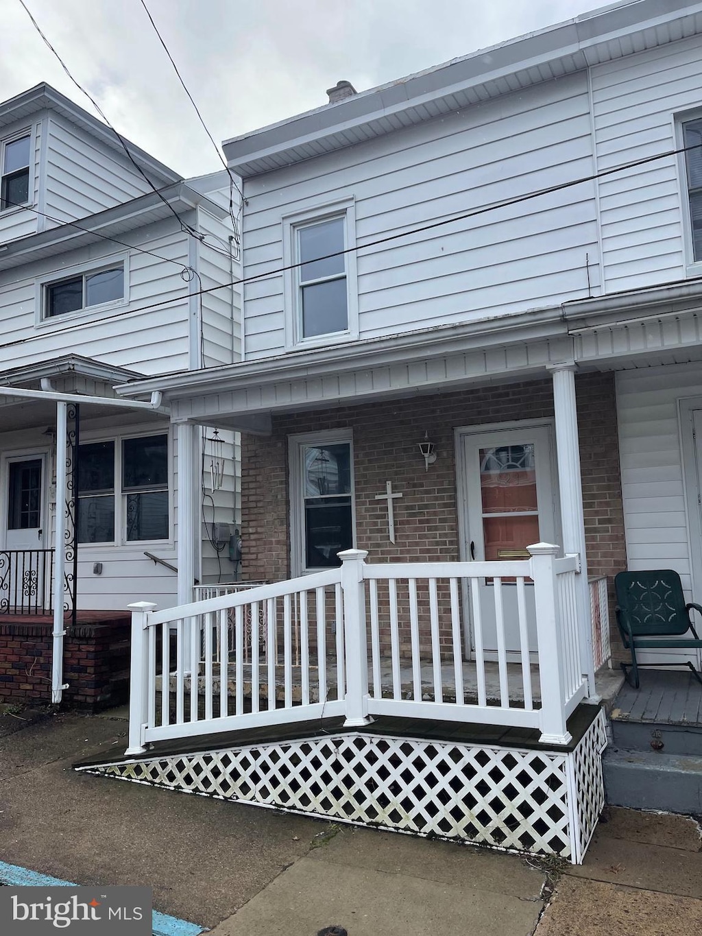 view of front facade with brick siding and covered porch