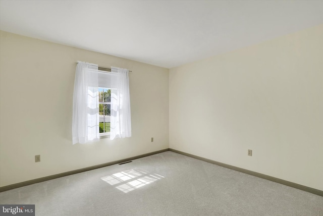 carpeted empty room with baseboards