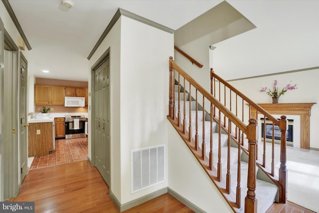 stairs featuring wood finished floors, recessed lighting, and baseboards