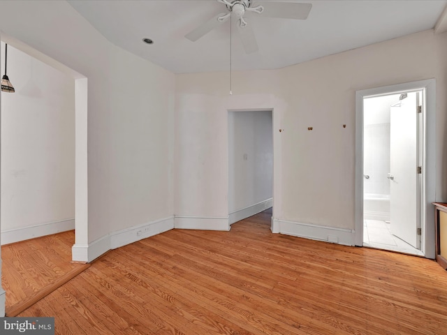 unfurnished room featuring baseboards, light wood-style flooring, and ceiling fan