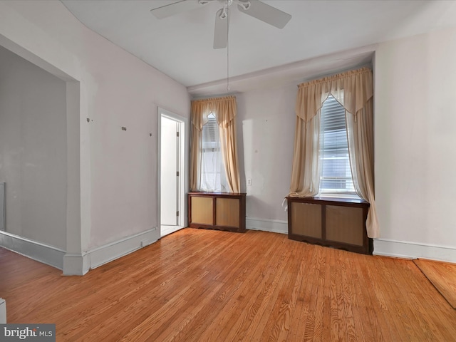 unfurnished room with ceiling fan, light wood-style flooring, baseboards, and a healthy amount of sunlight