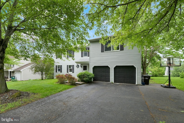 view of front of property featuring a garage, driveway, and a front yard