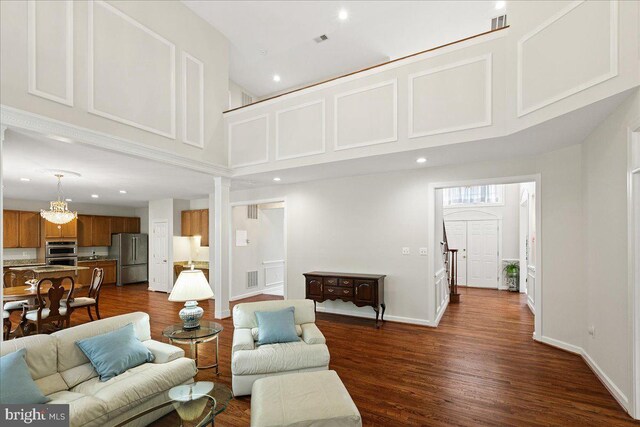 living area featuring a high ceiling, dark wood finished floors, recessed lighting, and baseboards