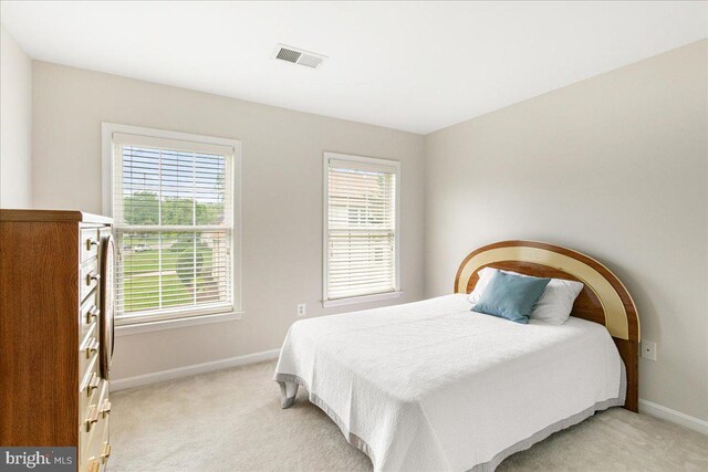bedroom with baseboards and light carpet