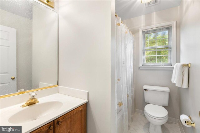 full bathroom featuring toilet, vanity, tile patterned floors, and a shower with shower curtain