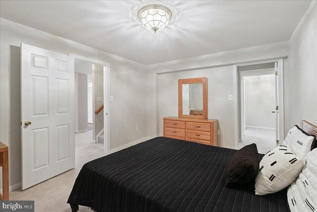bedroom featuring light colored carpet and baseboards