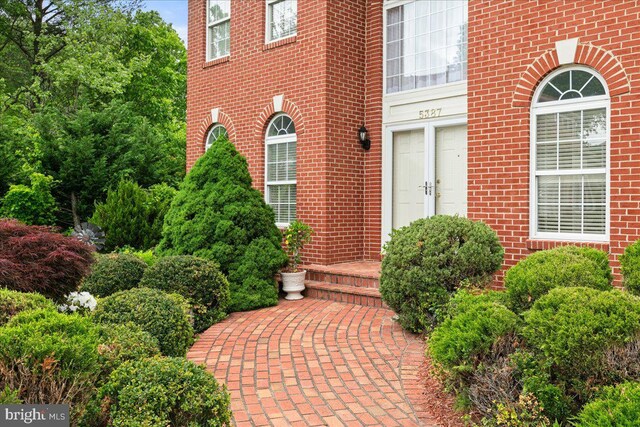 doorway to property featuring brick siding