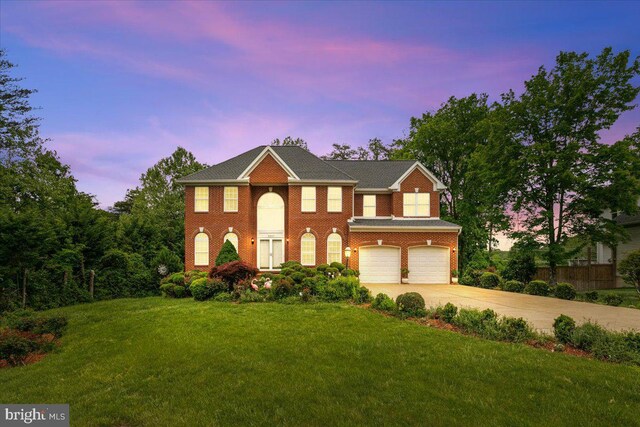 view of front of home featuring a garage, concrete driveway, and a front lawn