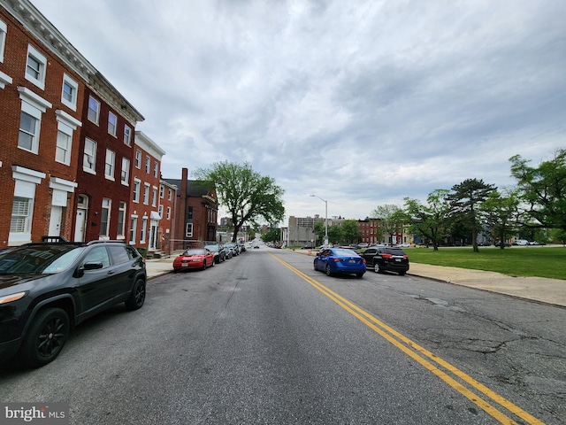 view of street with street lighting, curbs, sidewalks, and a residential view