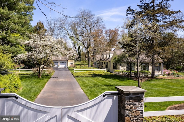view of home's community featuring a yard, driveway, and a garage