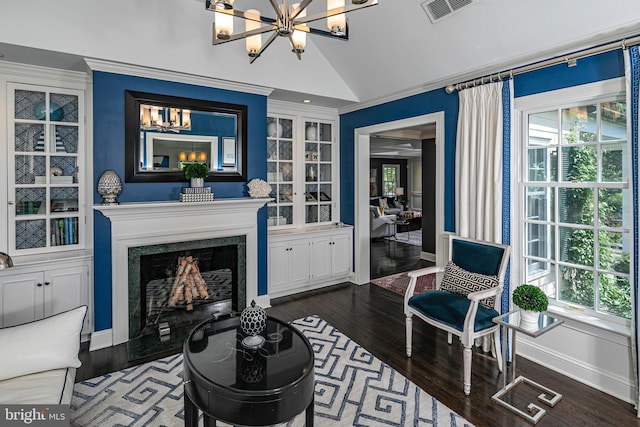 living area with a notable chandelier, dark wood-type flooring, and visible vents