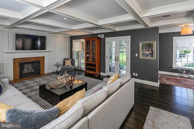 living area with coffered ceiling, crown molding, baseboards, beamed ceiling, and a large fireplace