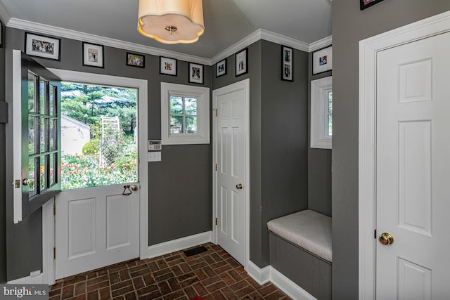 foyer entrance with baseboards, brick patterned floor, and crown molding