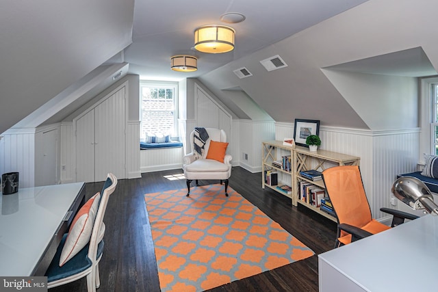 home office with lofted ceiling, a wainscoted wall, visible vents, and wood finished floors
